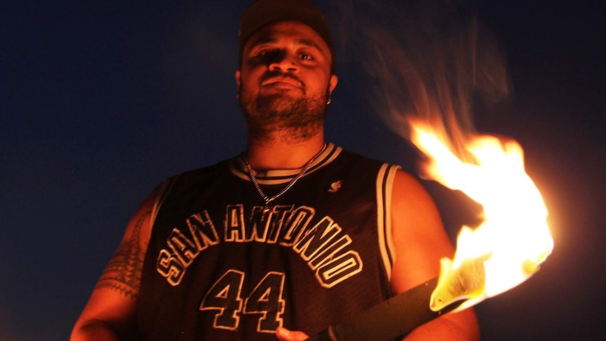 Samoan fire-spinner Hale Wilson holding a Samoan fire knife and looking into the camera.