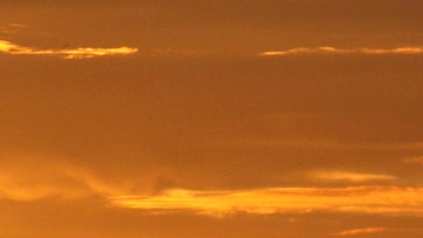 The sun sets over wind turbines