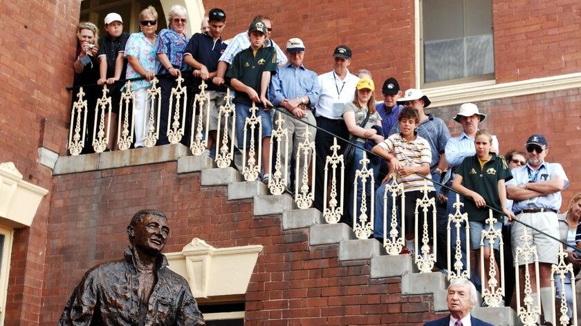 Richie Benaud speaks near a sculpture of himself