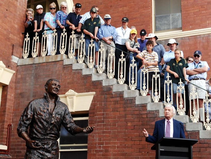 Former Australia captain Richie Benaud speaks near a sculpture of himself at the SCG
