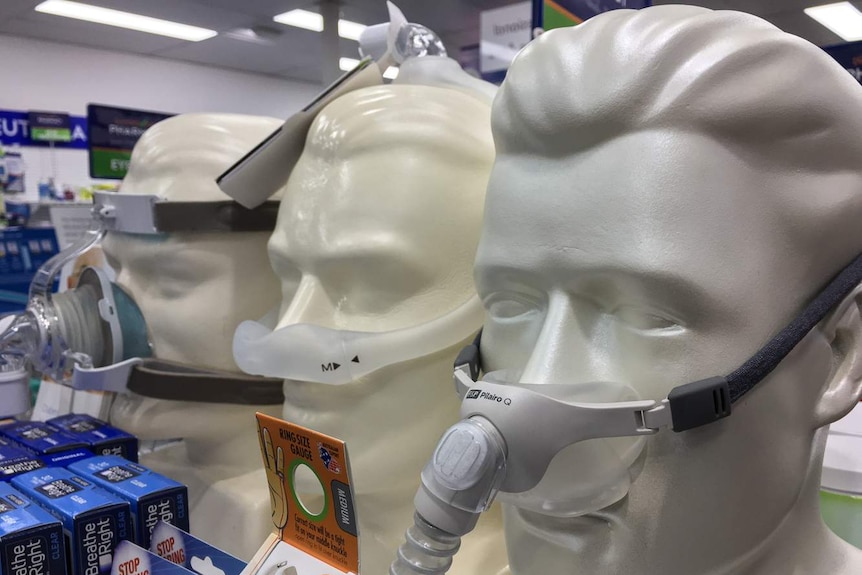 Three different CPAP masks on display on dummy heads in pharmacy
