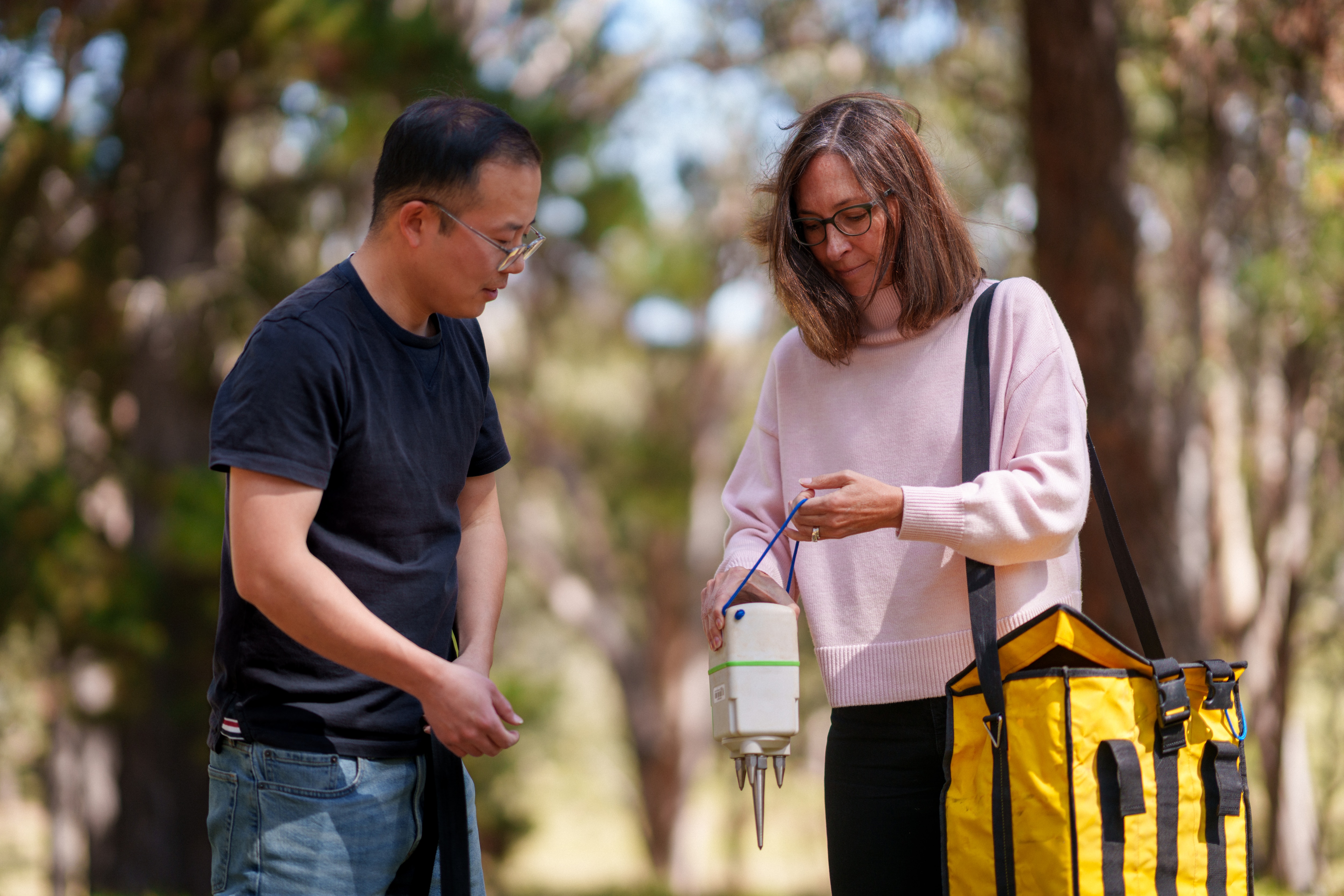 Dois cientistas estão sentados à mesa lendo uma folha de papel.