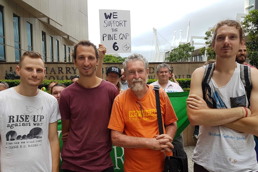 Four men and other protestors standing outside court in Brisbane