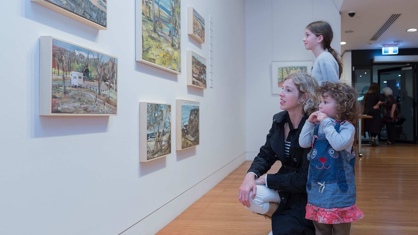 A family inspect artwork at the Coffs Harbour Regional Gallery.