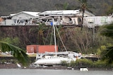 A boat is seen smashed against a bank at Shute Harbour