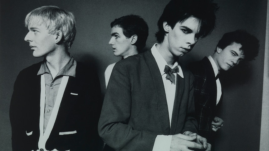 Black and white photo of Phill Calvert, Mick Harvey, Nick Cave, Tracy Pew all wearing jackets