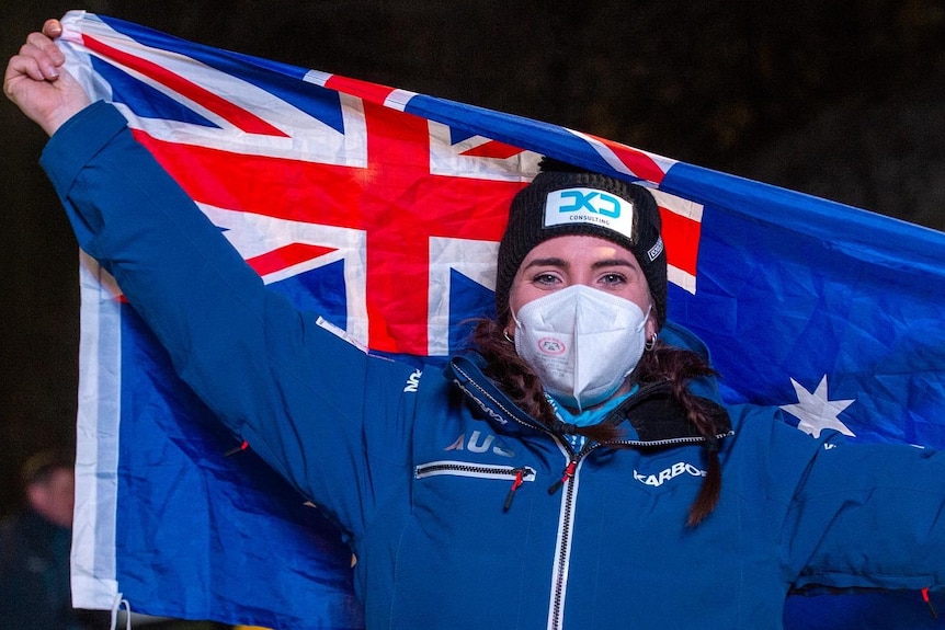 Austrālijas bobsleja skrējēja Brī Vokera rokās tur Austrālijas karogu