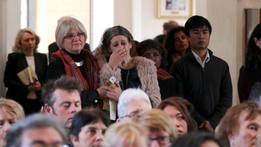 A woman sobs during a memorial service for victims of MH17