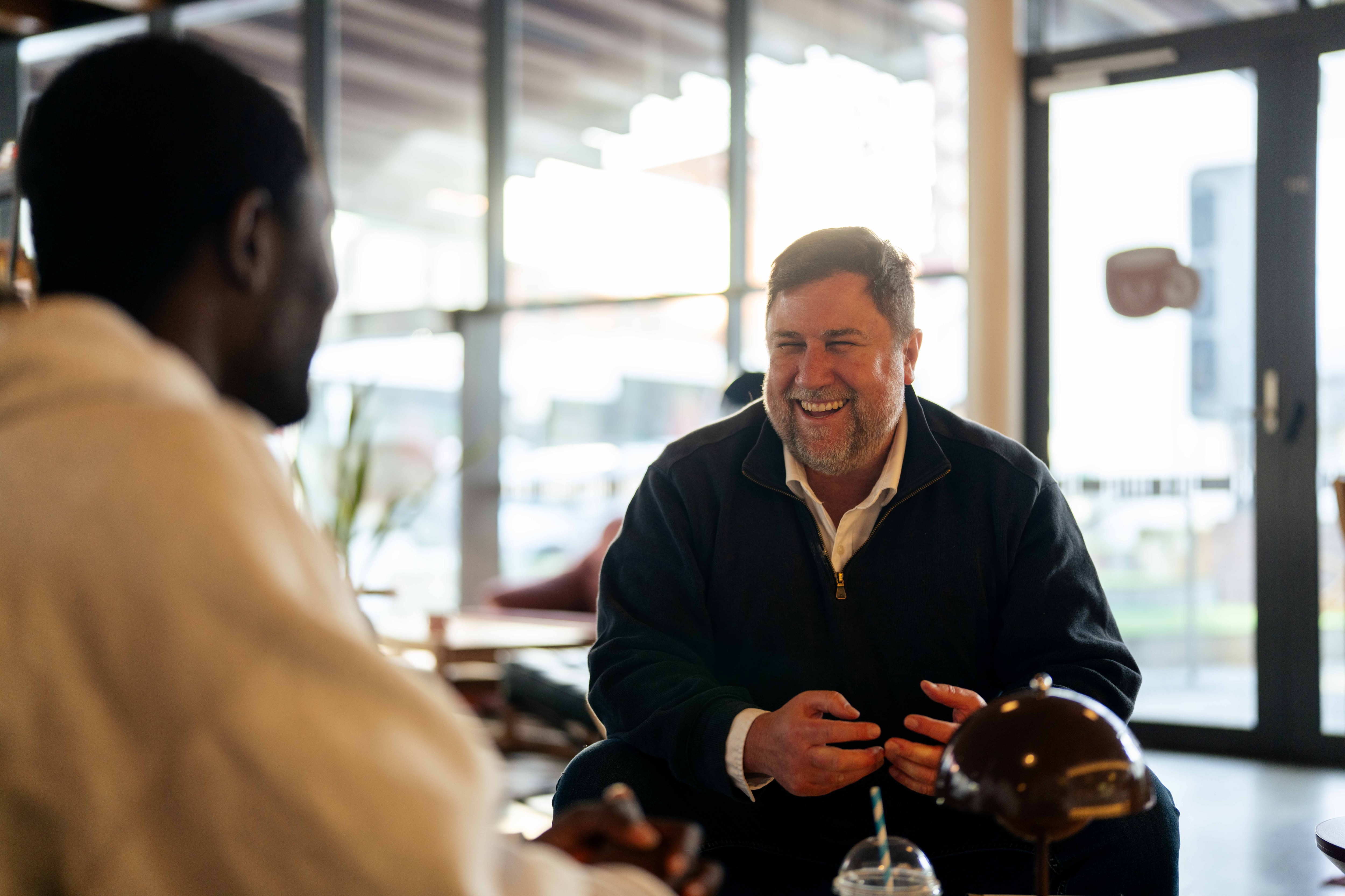 Two men chat at a cafe