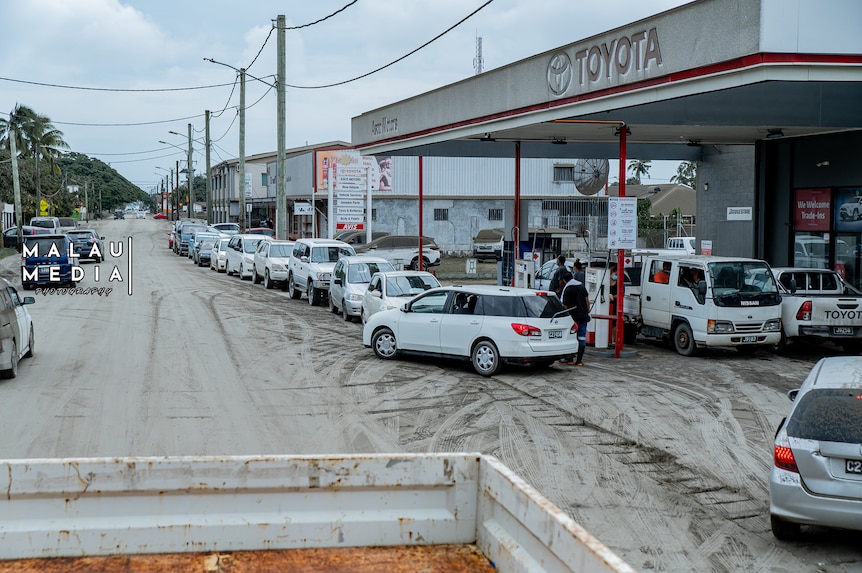 Toyota petrol station with car lining up to refuel. Ash everywhere ater a volcanic eruption in Tonga.