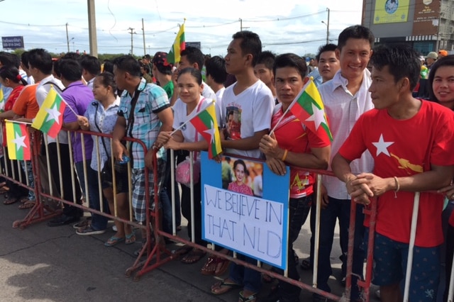 Crowds of Myanmar citizens with signs turn out to greet Aung San Suu Kyi at Thai Talay seafood market, south of Bangkok.