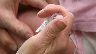 A doctor's hand injecting a vaccination needle into a patient's arm