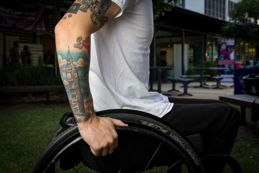 Rheed McCracken's arm rests on his wheelchair.