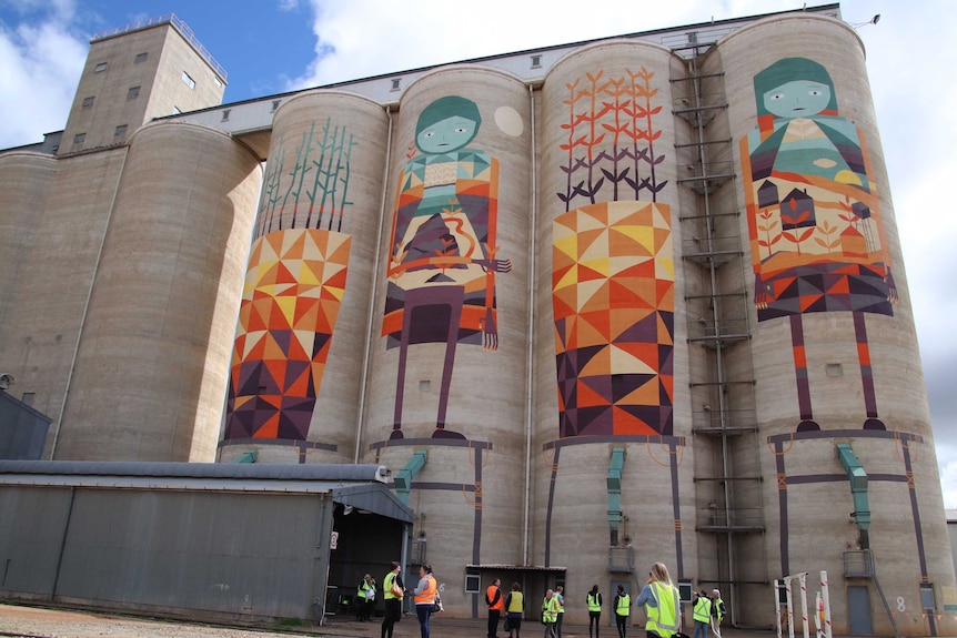 The four painted silos, with a number of people standing in the foreground.