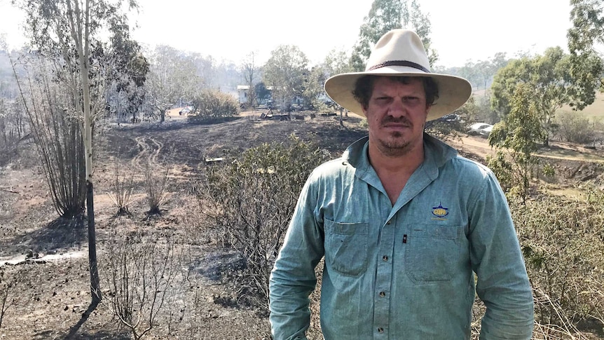 Nathan Corbett stands in front of scorched and his uncle's house