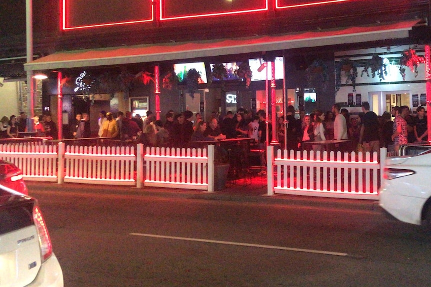A line-up of people standing outside a venue