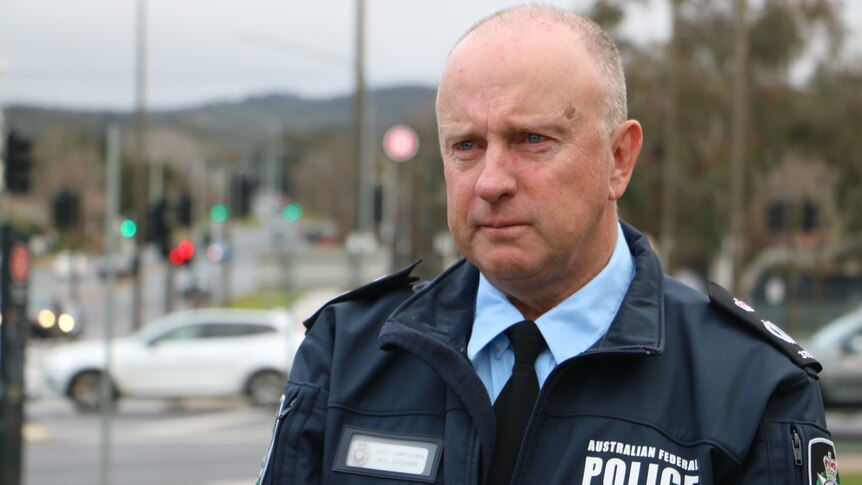 ACT Chief Police Officer Neil Gaughan standing next to traffic lights