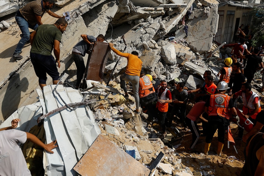 Palestinians search for casualties at the site of an Israeli strike on a house, in Khan Younis, in the southern Gaza Strip.