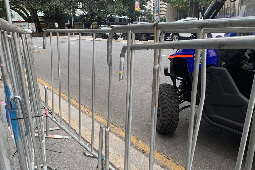 Temporary fencing on the side of a road has paling missing from where police used bolt cutters to release protesters.