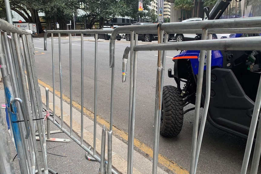 Temporary fencing on the side of a road has paling missing from where police used bolt cutters to release protesters.