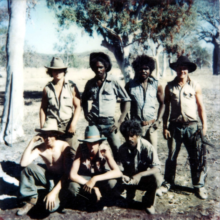 Old photograph of a group of seven men standing in two rows.