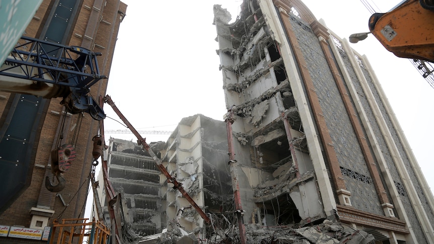 A gaping hole is left in the skyline, and a mass of rubble lies on the ground after a section of a 10-storey building collapsed