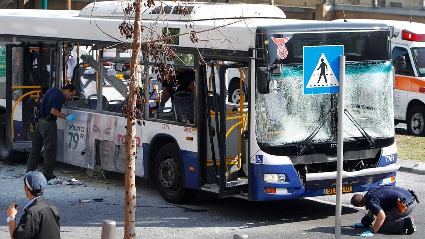 Israeli police survey the scene after an explosion on a bus in Tel Aviv.