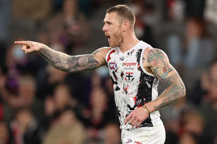 A St Kilda AFL player points a finger as he celebrates a goal.