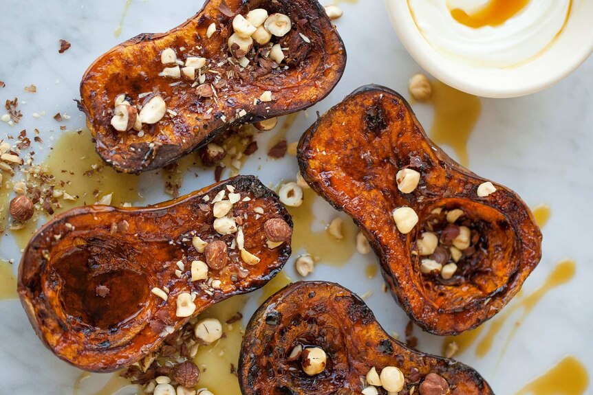 Four delicious roasted pumpkin halves topped with nuts.