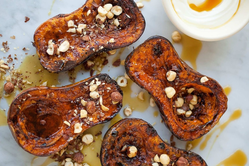 Four delicious roasted pumpkin halves topped with nuts.