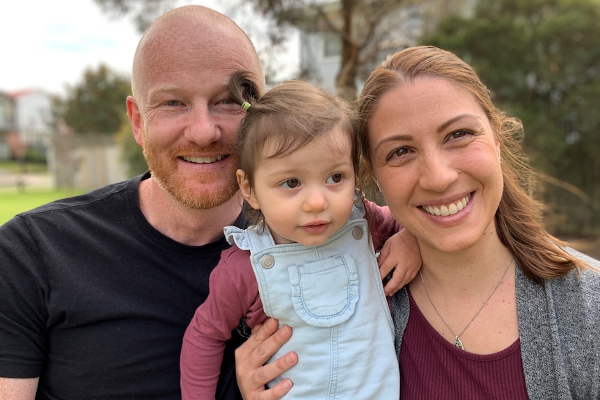 A man, woman and child in a park