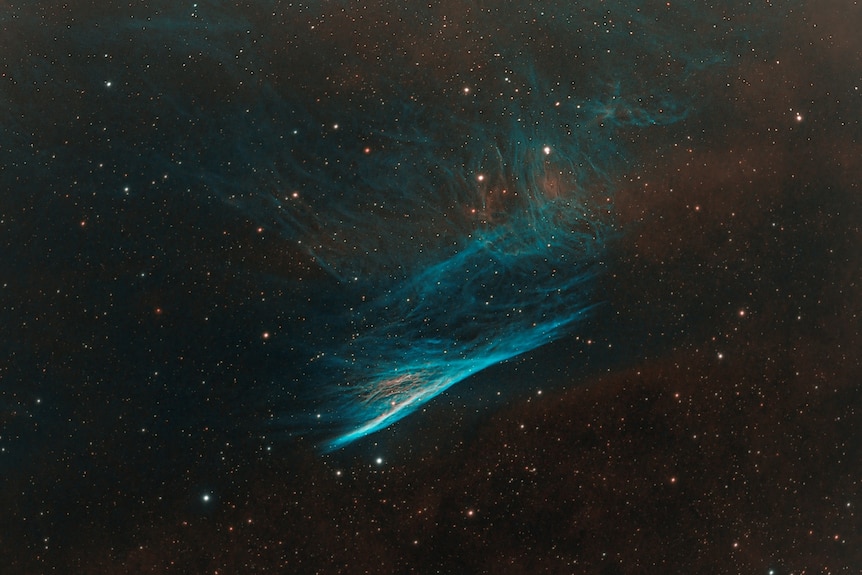 a bluish red nebula captured through a telescope