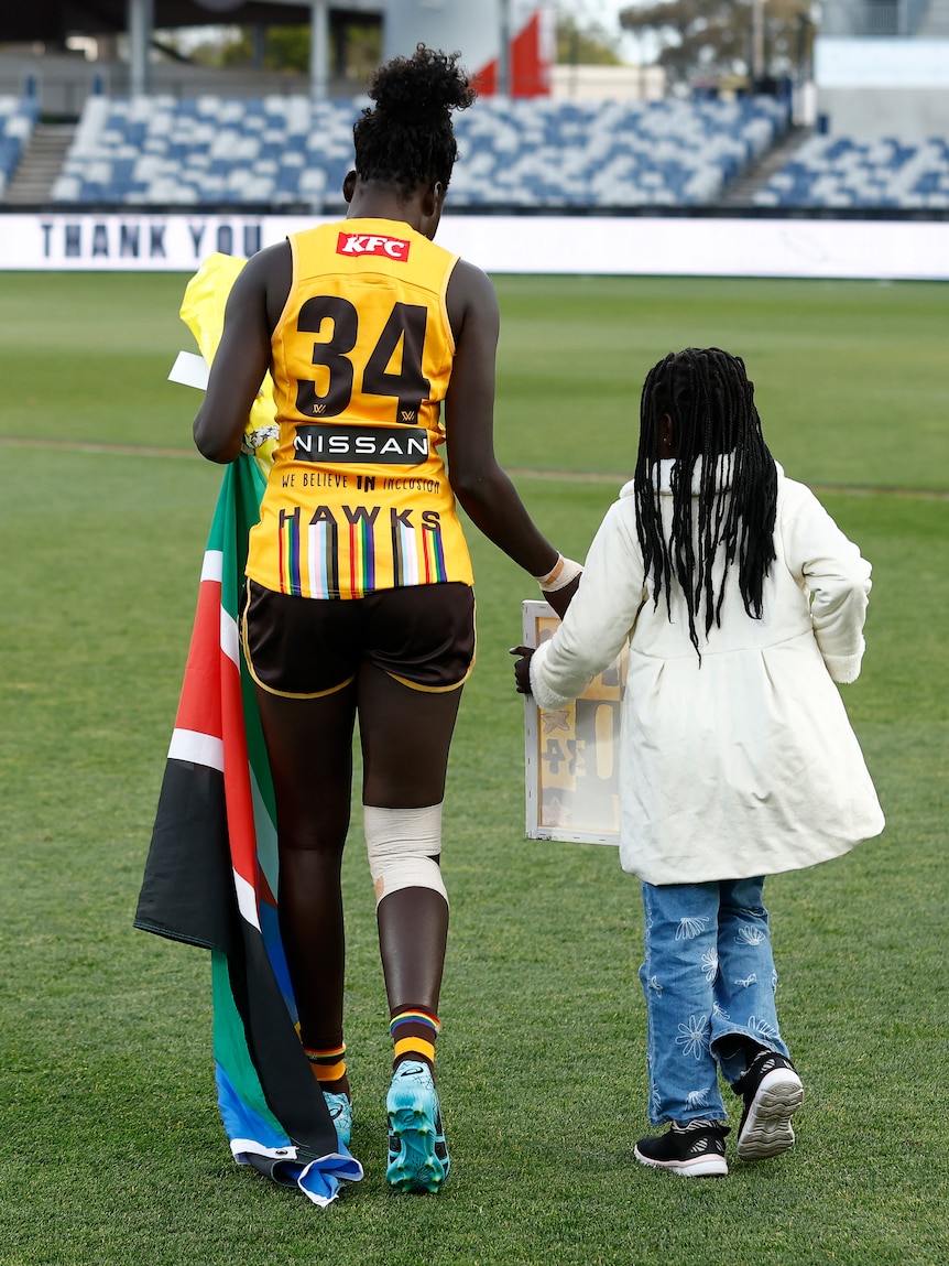  Akec Makur Chuot of the Hawks leaves the field with her niece after her final match during the 2023 AFLW Round 10 match