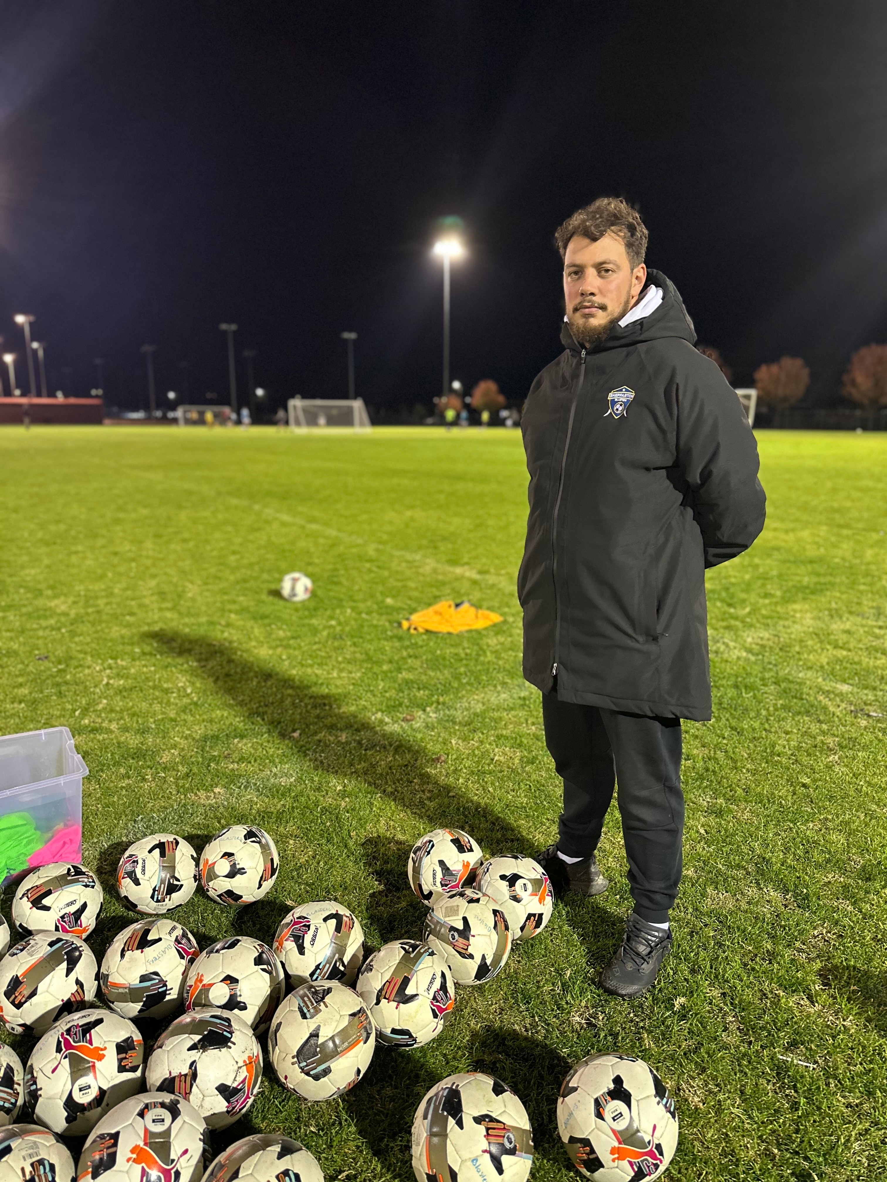 Soccer coach wearing black jacket in the ground