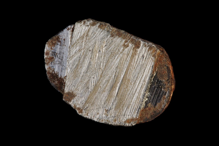 A close up photo of a rock against a black background.