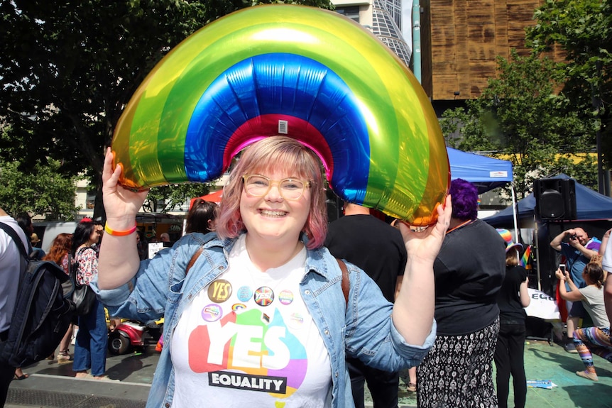 Amalie O'Hara holds a rainbow balloon above her head at the yes event in Melbourne