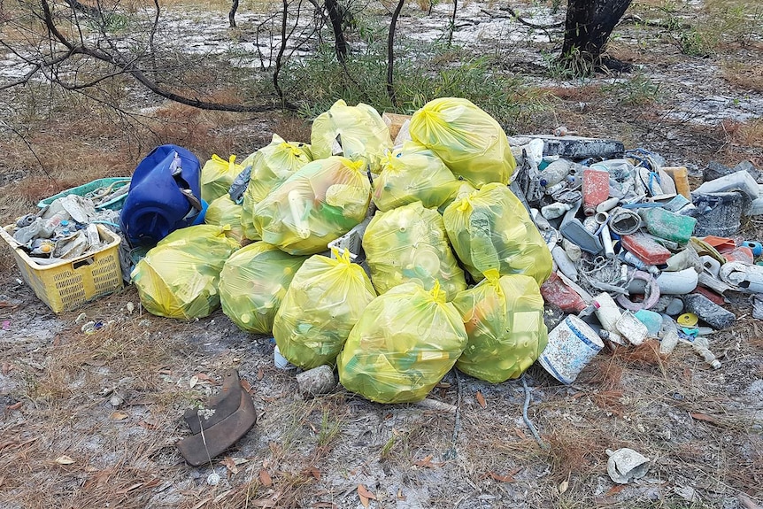 foto tumpukan kantong sampah yang berhasil dikumpulkan dari pantai.