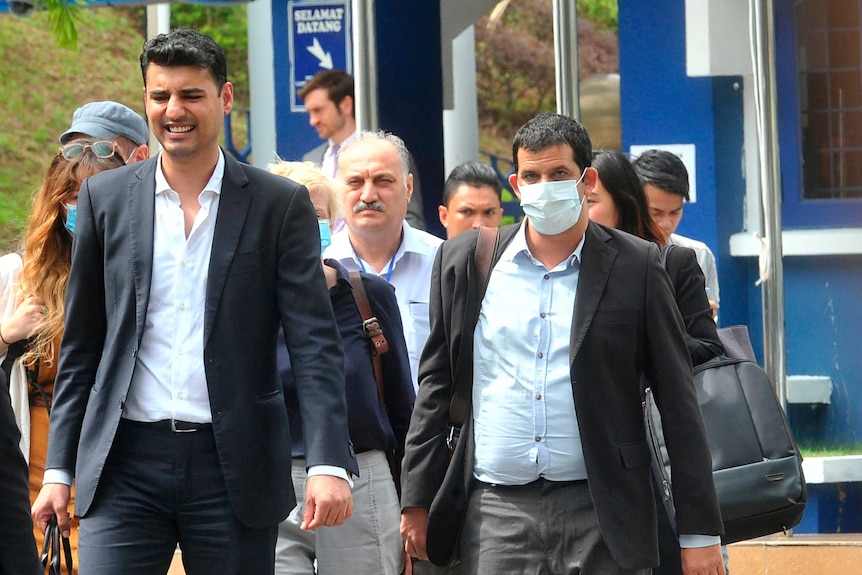 Australian Al Jazeera journalist Drew Ambrose, right, leaves the Bukit Aman police headquarters in Kuala Lumpur.