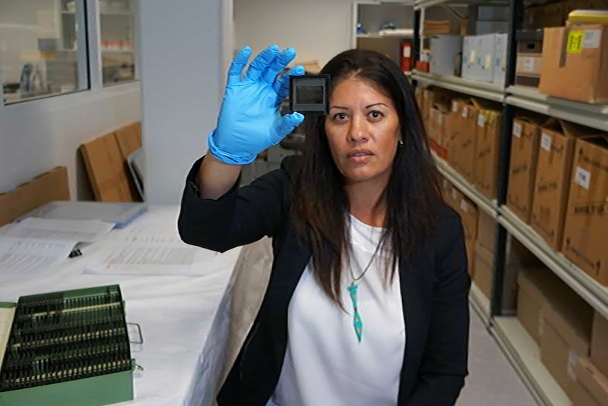 University of WA researcher Donna Oxenham holds up a slide.