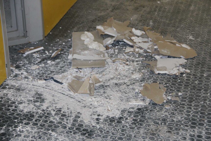 Damaged board and debris on the floor of Banksia Hill Detention Centre.