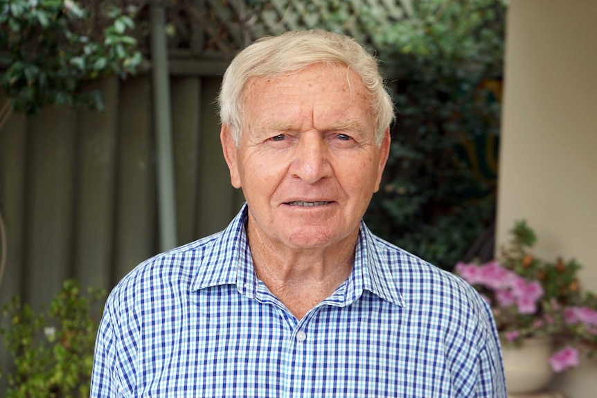 A head and shoulder shot of Barry Cable standing in a courtyard.