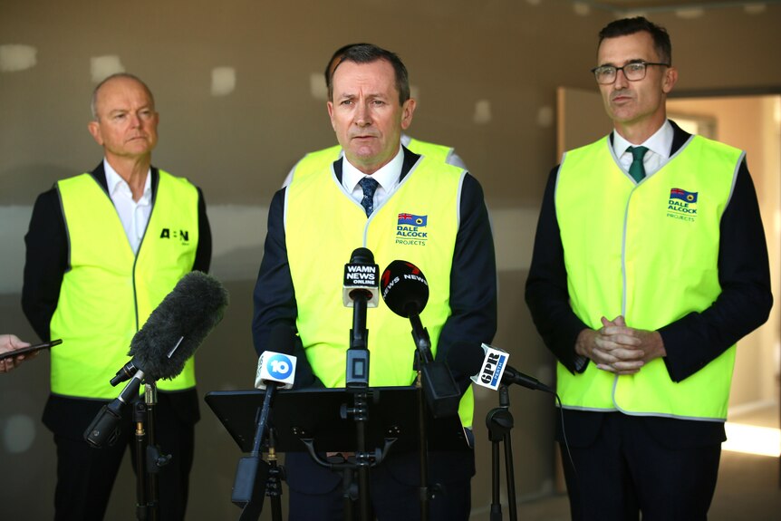 Mark McGowan flanked by Dale Alcock and John Carey at a media conference, with all three wearing yellow hi-vis vests.