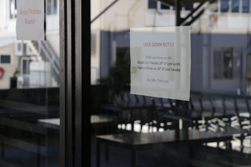 A lockdown notice is seen stuck to a shop window.