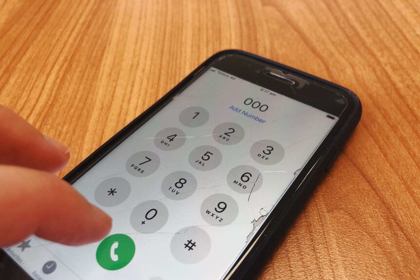 A mobile phone with the Triple Zero number displayed on the keypad.
