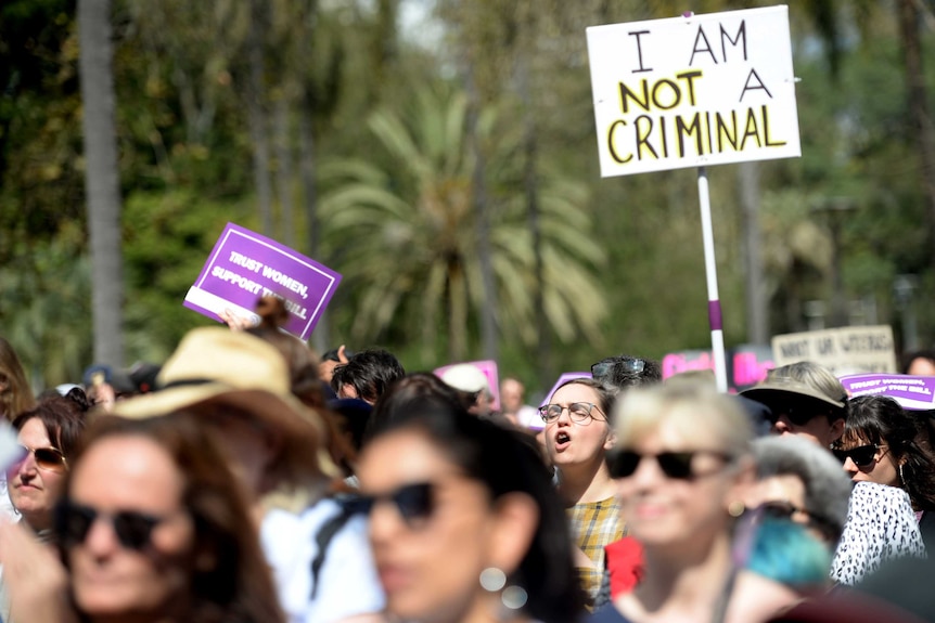 Someone holds a sign which reads 'I am not a criminal' amid an abortion protest