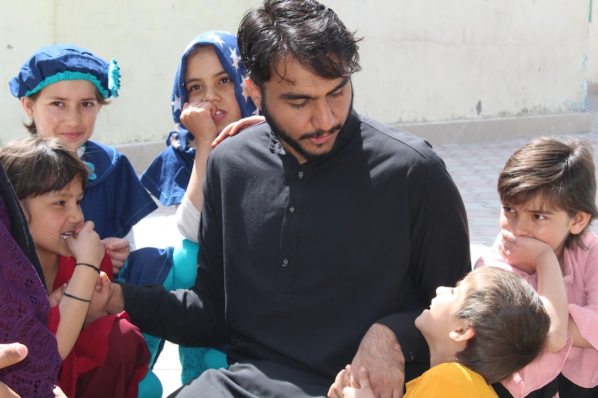 A man stands with a group of children