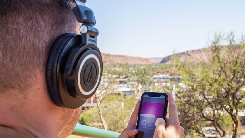 A man looks at a phone with the Gap in the background