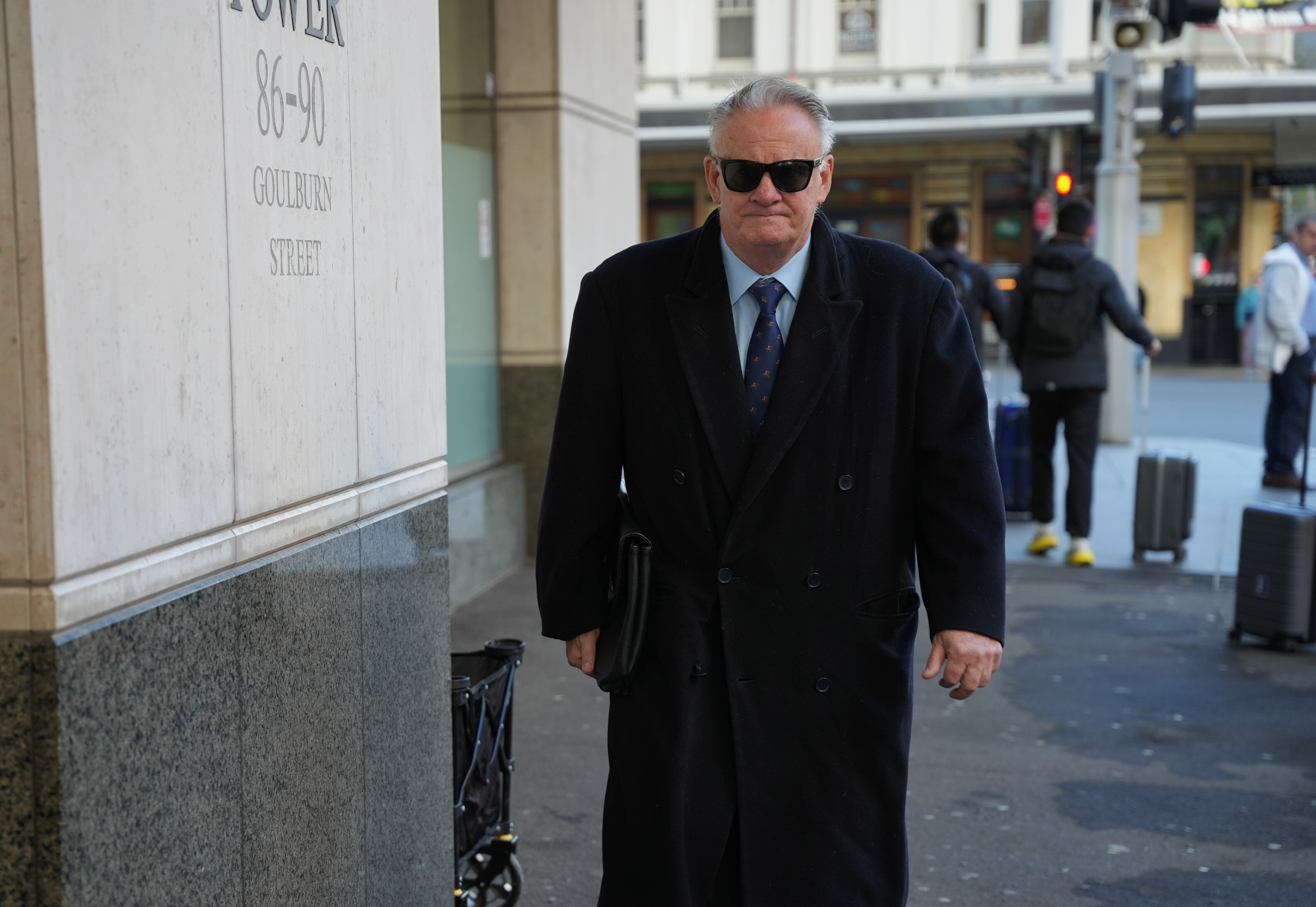 Mark Latham in sunglasses and large overcoat