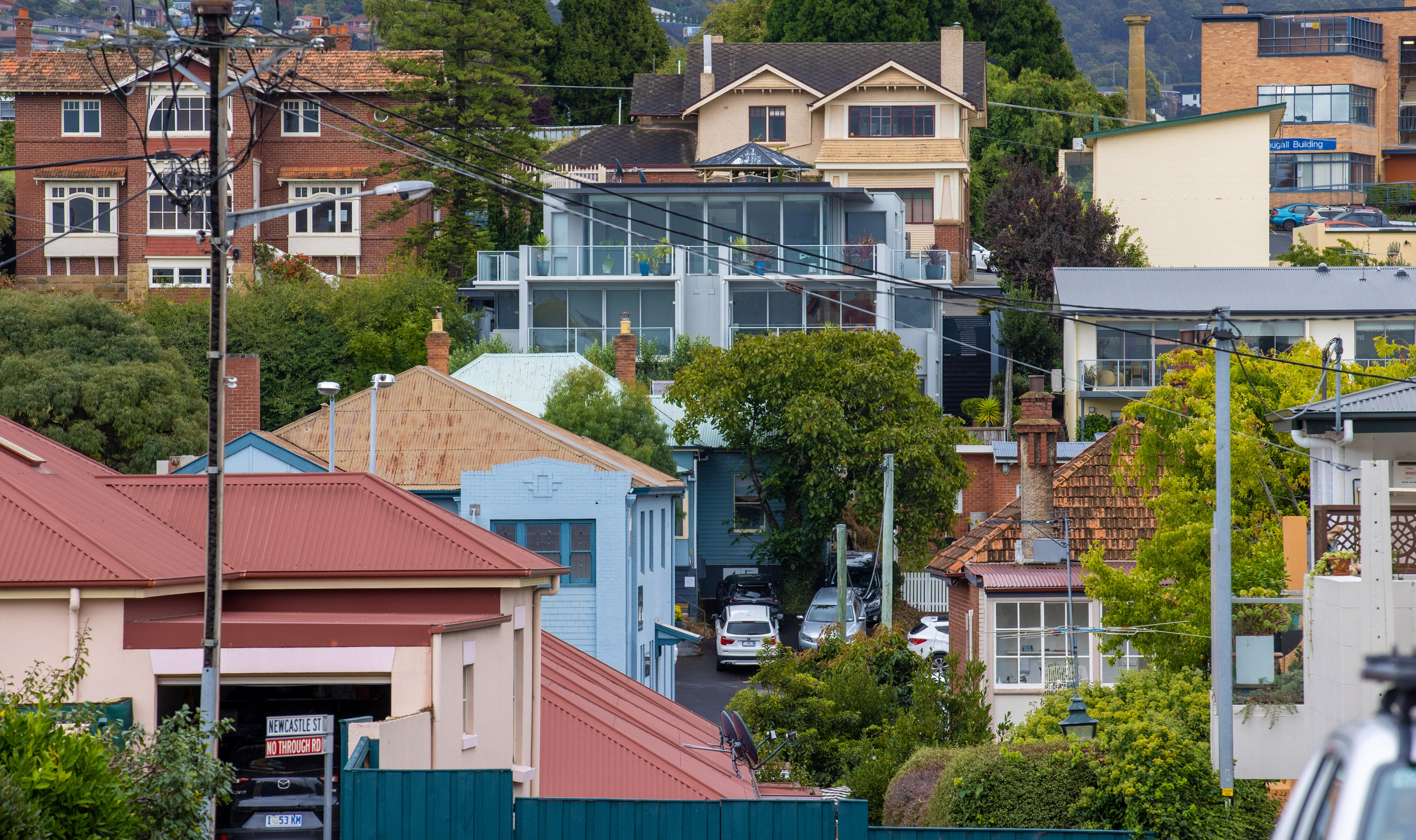 Multiple houses grouped together at different levels on a hillside.