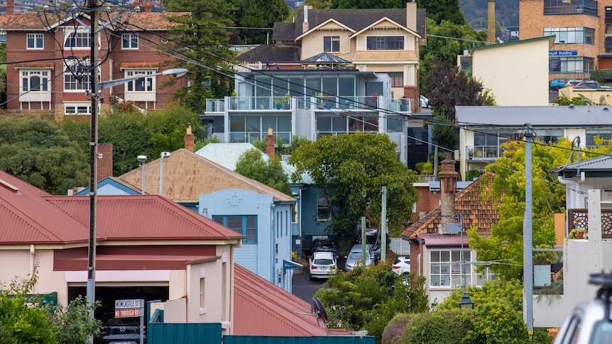 Multiple houses grouped together at different levels on a hillside.